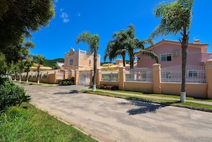 Una calle residencial con casas, palmeras y un cielo azul despejado.