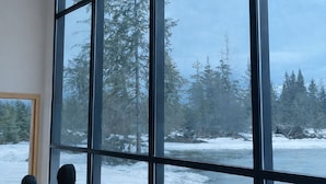 A large window with a view of a snowy landscape and trees.