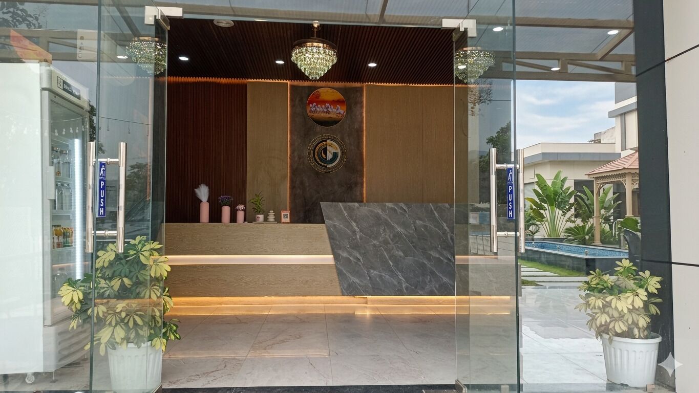 A reception area with a marble counter, a chandelier, and a sign with a circular emblem.