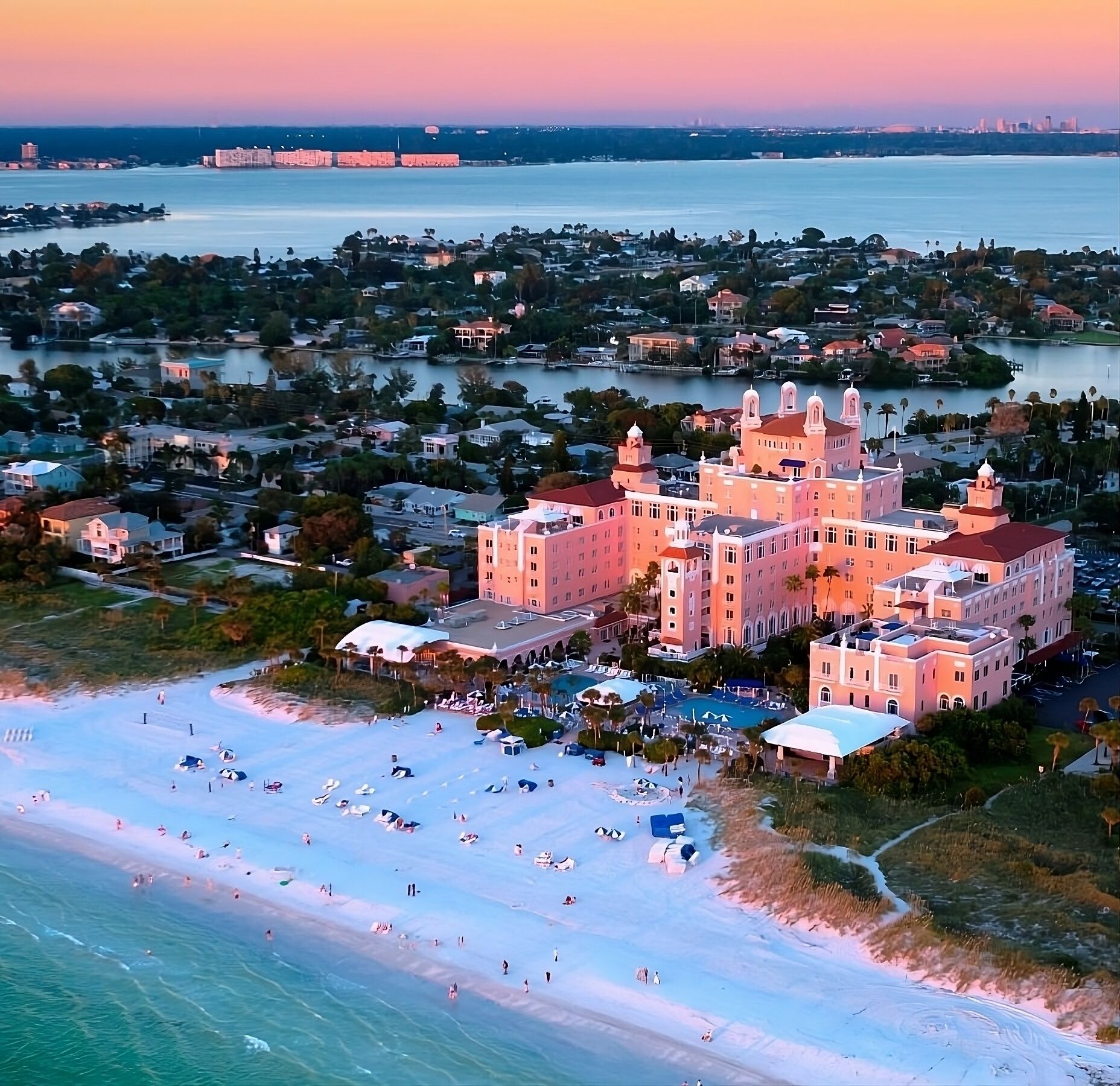 Marvel at sunset colors over a sprawling beachfront retreat.