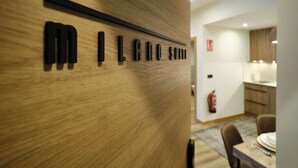 Un mur en bois sur lequel est inscrit le texte « MILANO SUITE », avec une barre horizontale noire au-dessus.