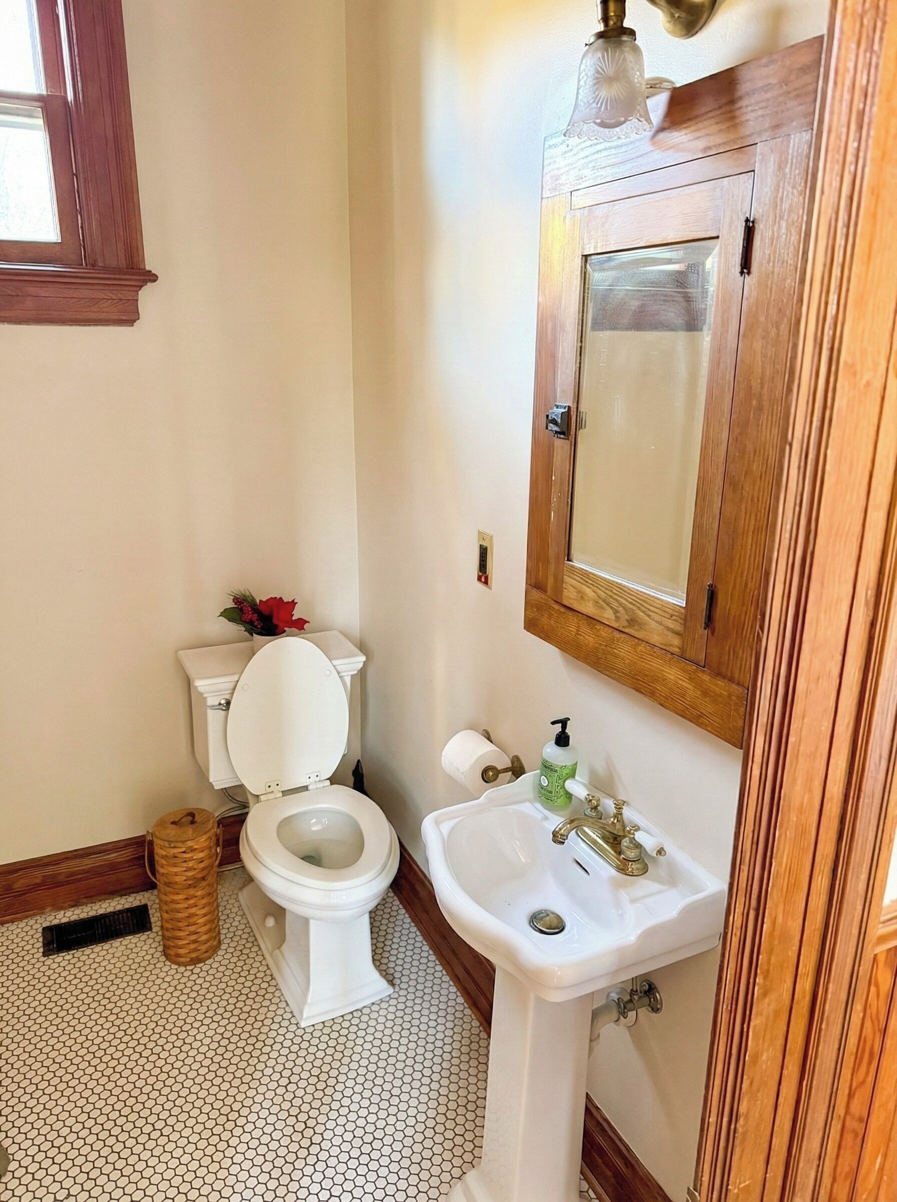 Un baño con inodoro, lavabo y armario de madera.