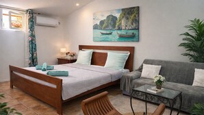 Une chambre à coucher avec un lit, un canapé, une table basse et un fauteuil.
