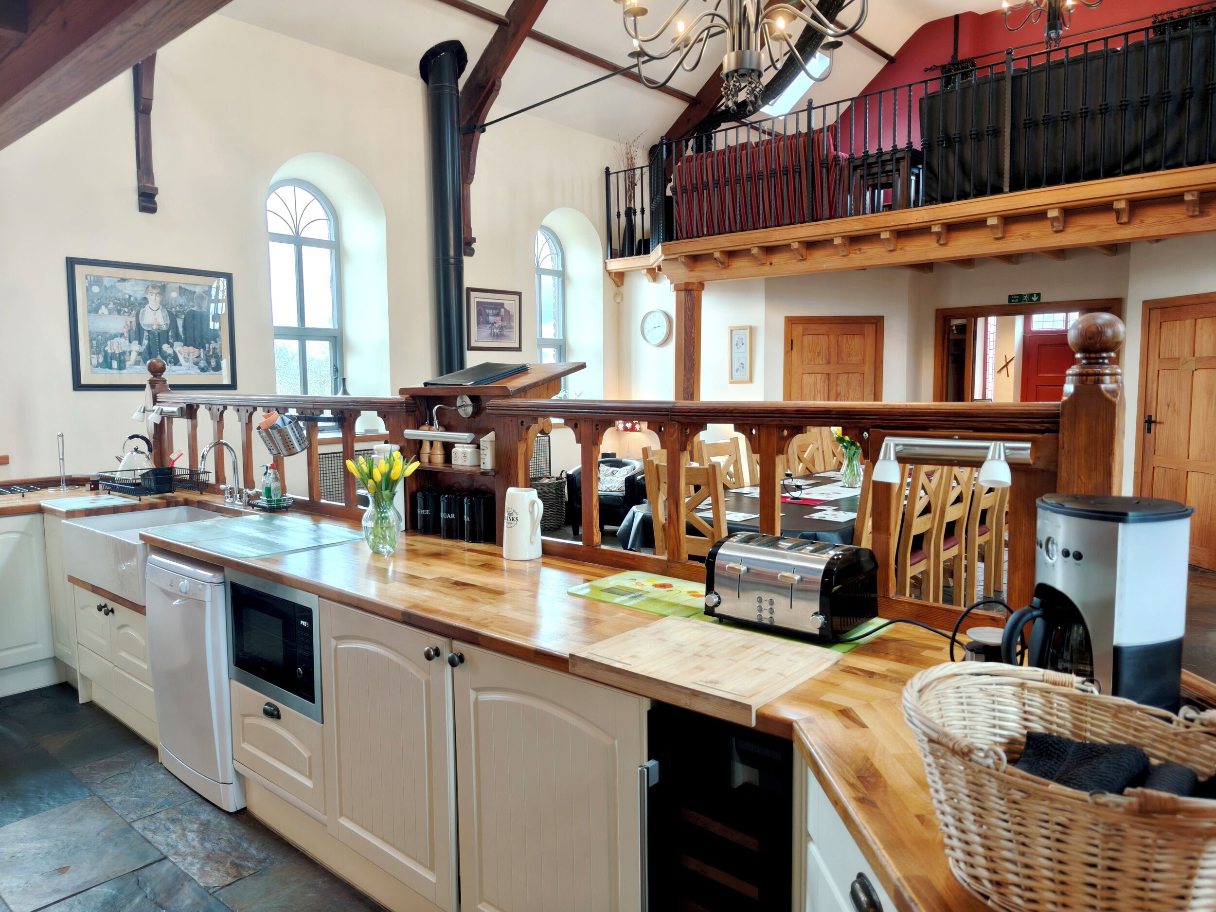 Uma cozinha espaçosa com bancada de madeira, máquina de lavar louça embutida e uma ilha grande com assentos.