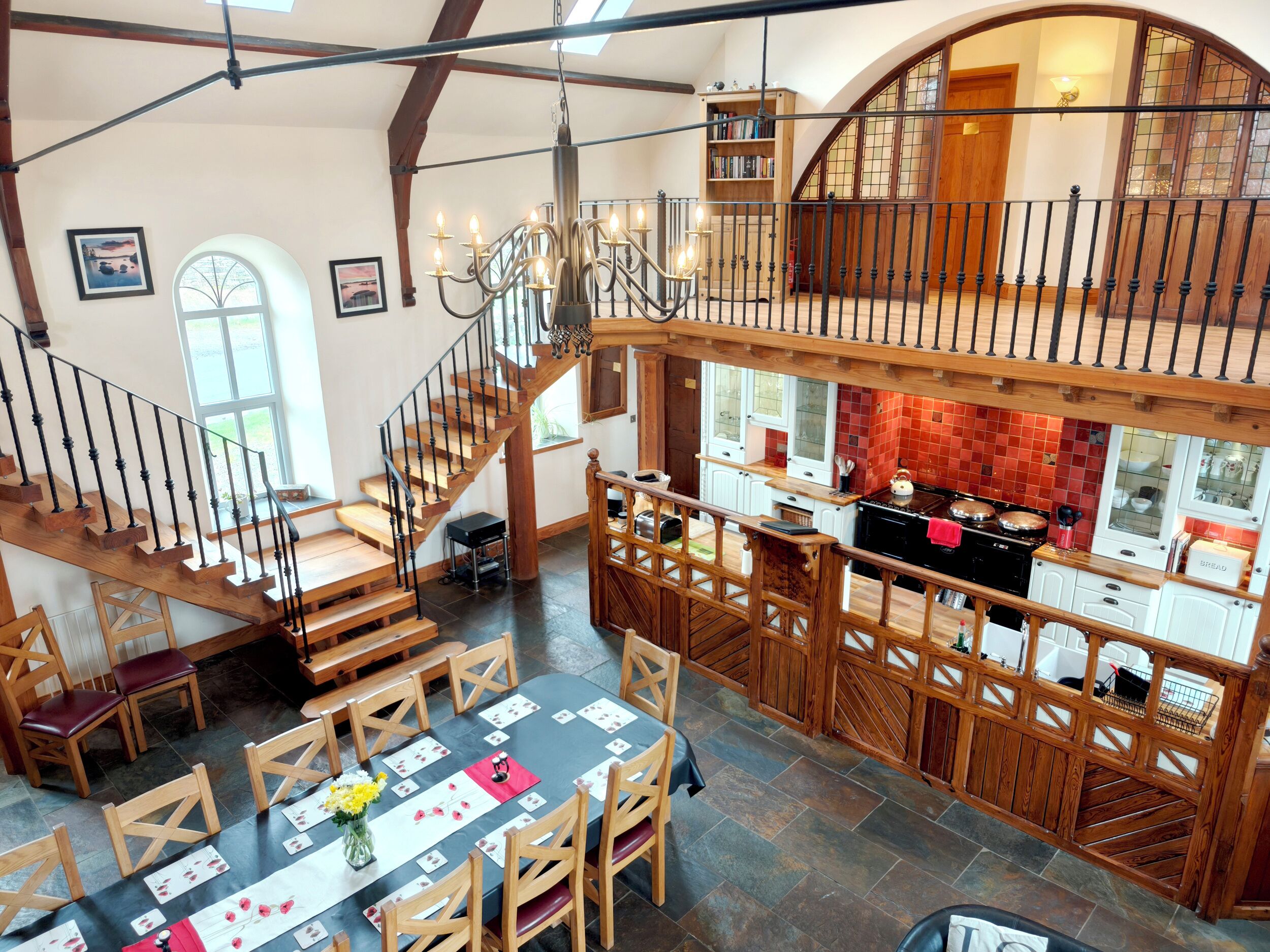 A spacious dining area with a high ceiling and a staircase leading to an upper level.