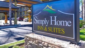 Señal para Simply Home Inn & Suites con un gráfico de montaña y ola.