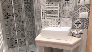 A bathroom with a shower, a sink, and a toilet. - Antico Portale (Acquasparta)