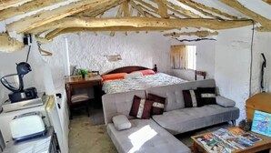 Une chambre à coucher de style rustique, avec un lit, un canapé, un bureau et un lave-linge.
