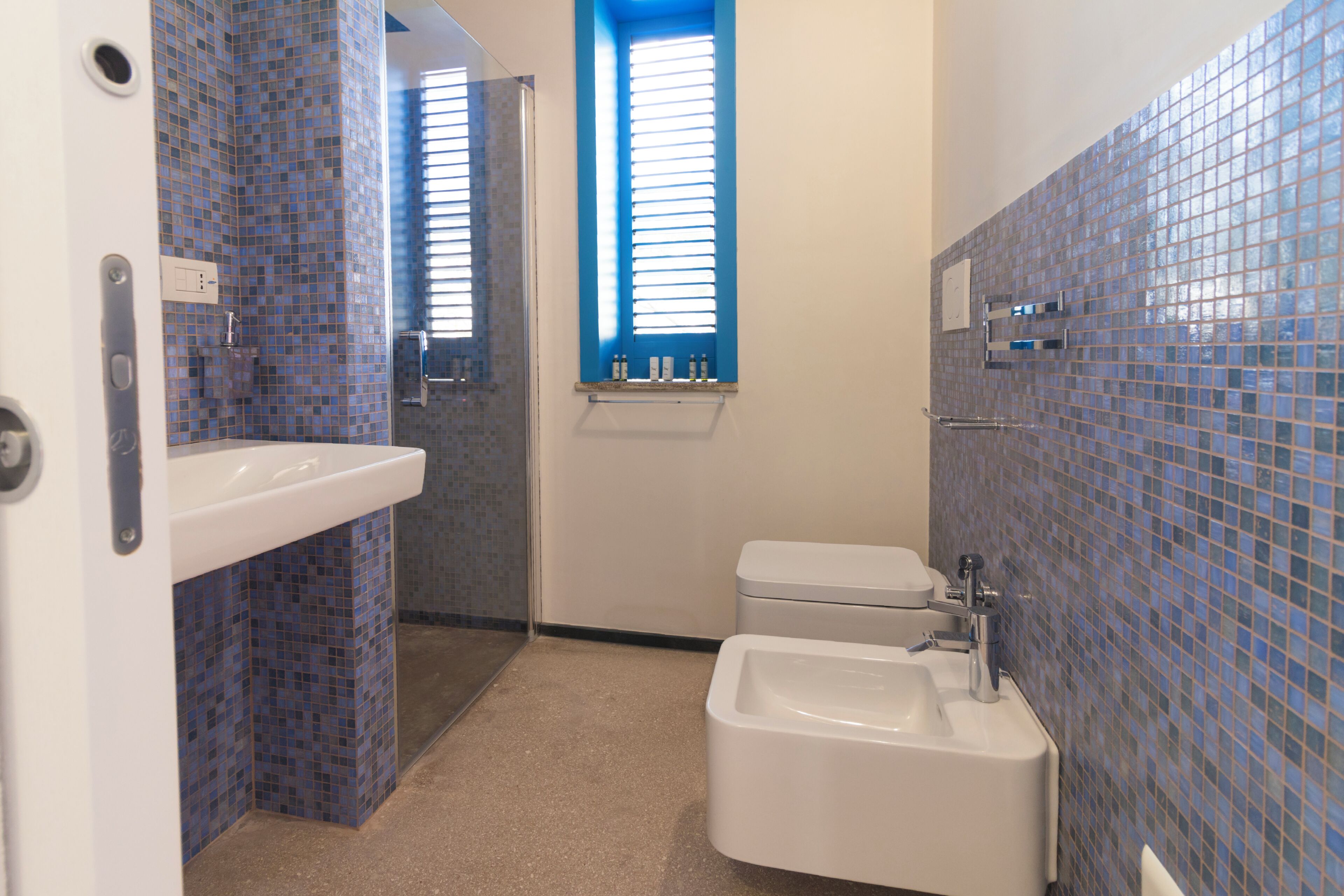A bathroom with a white sink, a bidet, and a toilet.