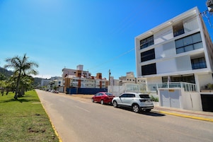 Una calle con coches aparcados, edificios y cielo despejado.