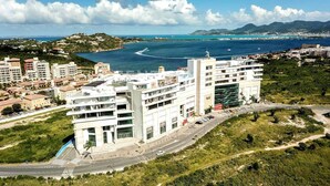 A coastal cityscape with modern buildings, a marina, and a clear view of the sea.