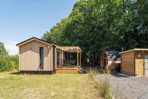A wooden cabin with a porch and a small attached structure.