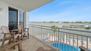 Ein Balkon mit Stühlen, einem Pool und Blick auf eine Marina.