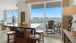 Ein Balkon mit Blick auf eine Marina, ein Holztisch mit Stühlen und einem Fernseher.