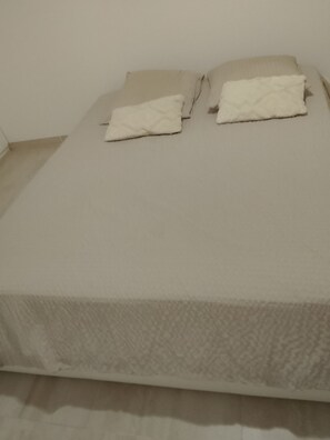 Un lit avec une couvre-lit à motifs et deux oreillers.