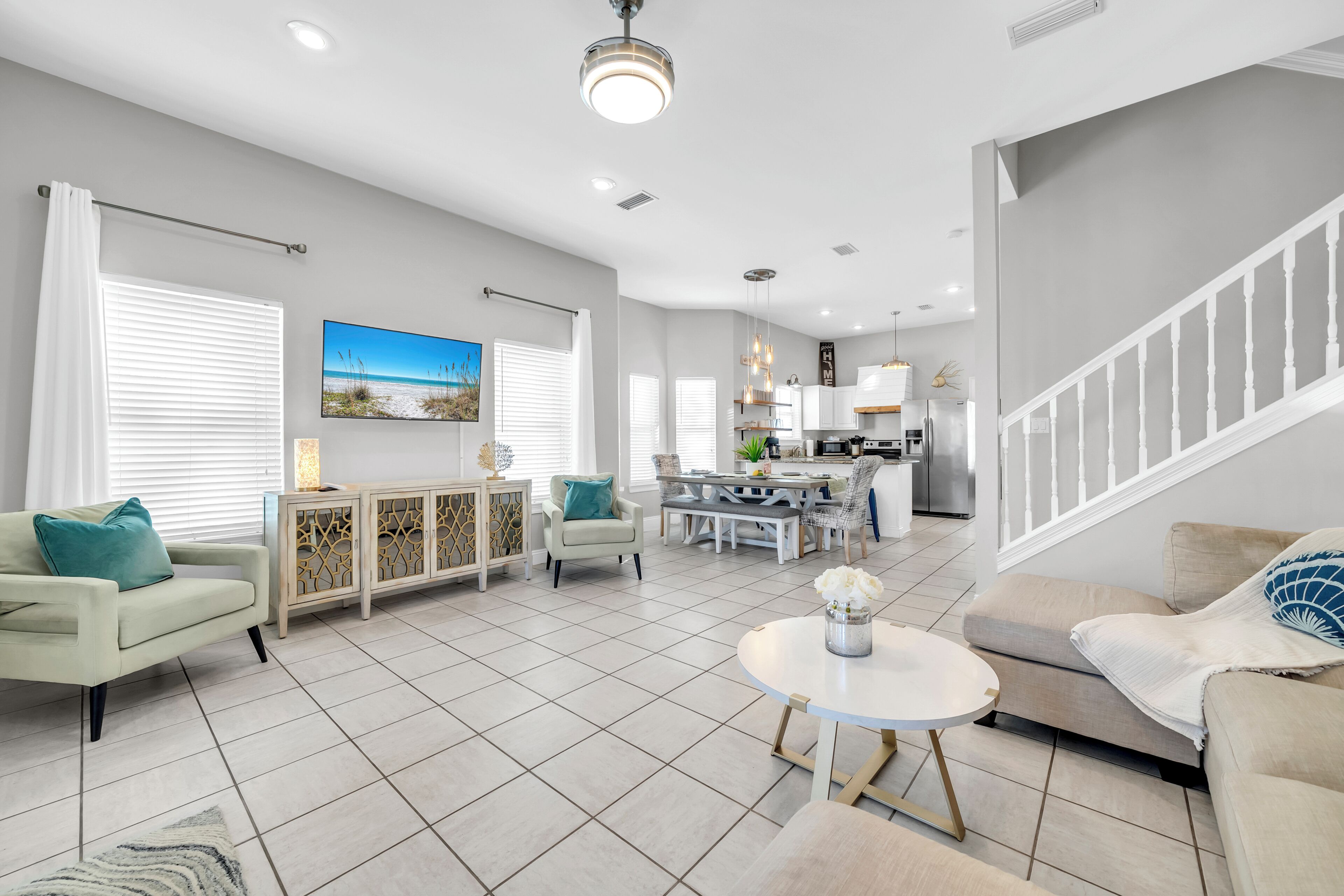 Una sala de estar moderna con comedor, cocina y escalera.