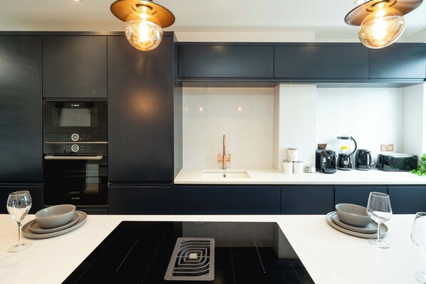 A modern kitchen with a Bosch oven, a sink, and a coffee machine. - Gorgeous 3BR with 2bath in O2 | Greenwich | Parking (London)