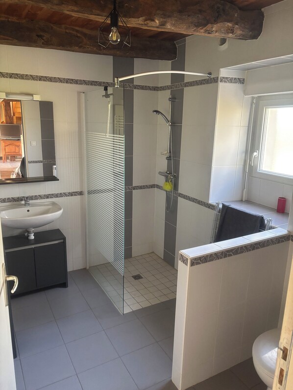 Ein Badezimmer mit Dusche, Waschbecken und Toilette.