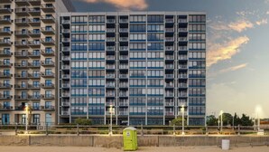 Hotel modern amb diverses plantes, balcons i vista al mar.