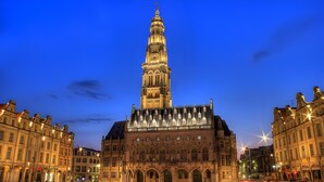 Ein historisches Gebäude mit einem markanten Turm, Rundbogenfenstern und einer Uhr.