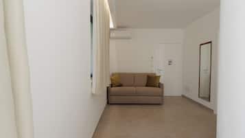 Habitación cuádruple, vista al jardín | Área de sala de estar