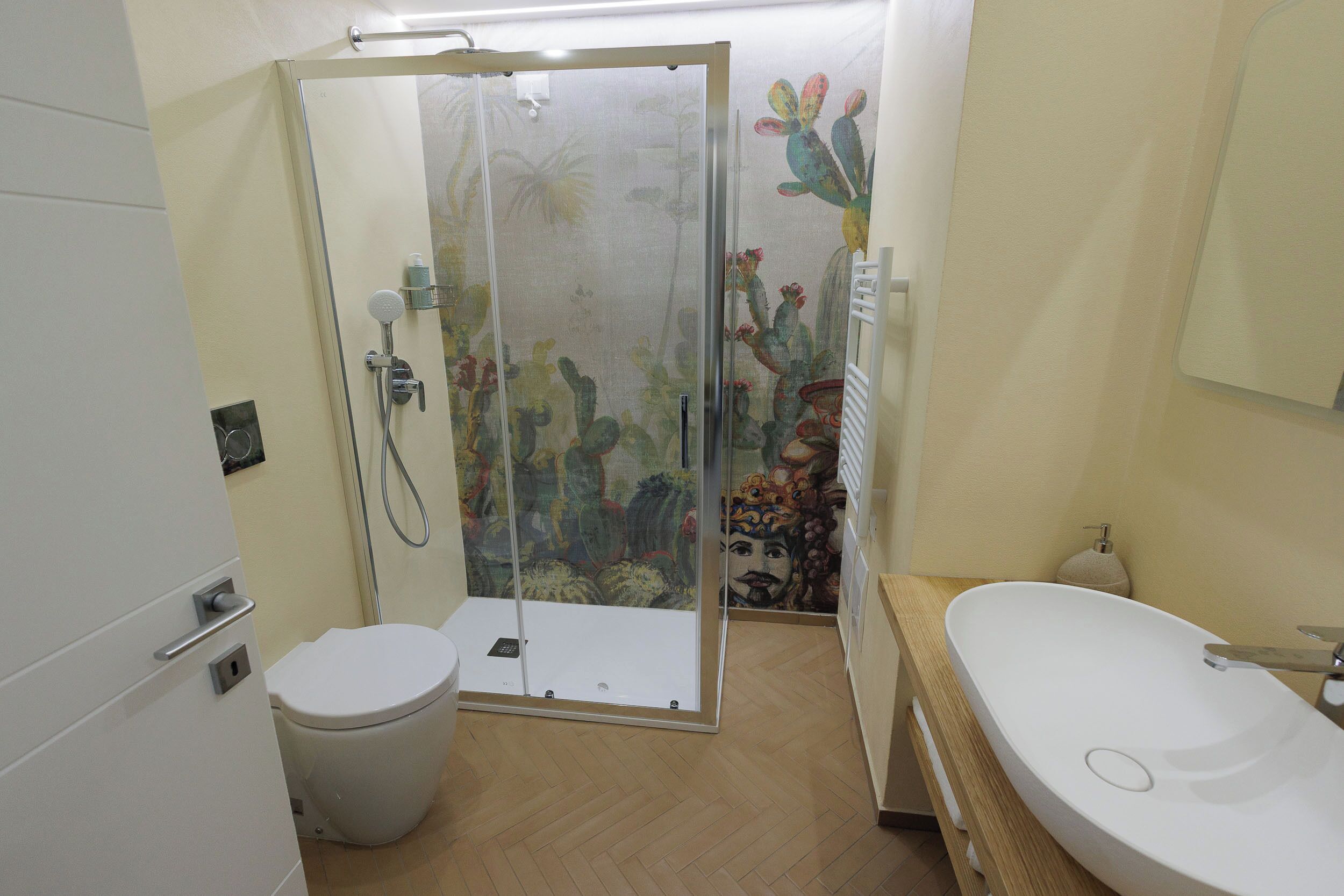 A bathroom with a shower enclosure, toilet, and sink.