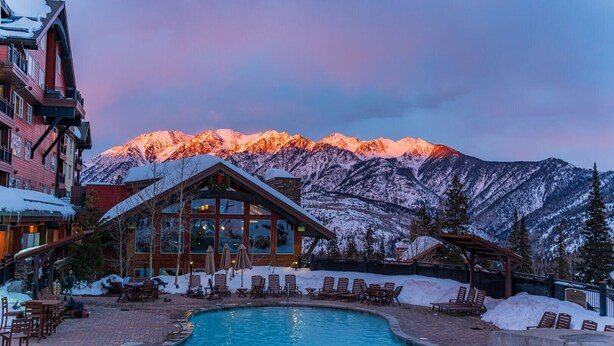 A resort with a pool, lounge chairs, and a mountain backdrop. - Lucky Star Lodge | Pool & Hot Tub | Fire Pit (Durango)
