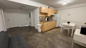 A compact living space with a kitchenette, a dining area, and a sofa. - Triangle Suites LLC (Hialeah)