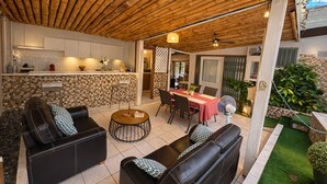 An outdoor patio with a dining table, chairs, and sofas.