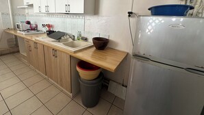 A kitchen with white cabinets, a sink, a stove, and a refrigerator.
