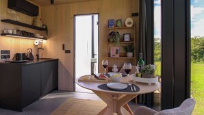 Een moderne keuken met een eetgedeelte, een groot raam en uitzicht op de omgeving.