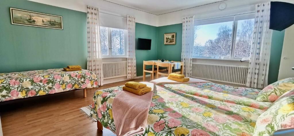 A room with two beds, a desk, and a chair.