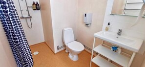 Une salle de bain comprenant des toilettes, un lavabo, une douche et un porte-serviettes.