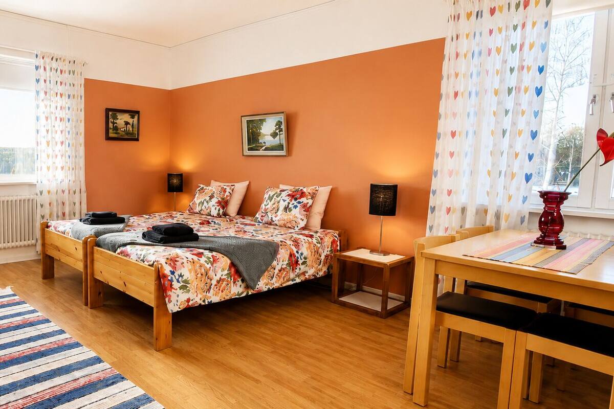 Ein Schlafzimmer mit Bett, Stuhl, Tisch und Fenster.