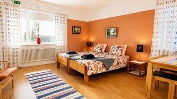 A bedroom with a bed, a chair, a table, and a window.