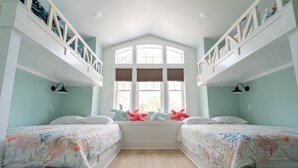 A room with two beds, a window with shutters, and a white ceiling. - Happy Tides Hideaway/NEW!/Pool/Kids Adventure Room (Oak Island)