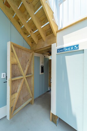 A wooden door leading to a shower area with a sign above it. - Happy Tides Hideaway/NEW!/Pool/Kids Adventure Room (Oak Island)