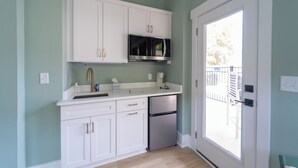 A kitchen with white cabinets, a stainless steel dishwasher, and a microwave. - Happy Tides Hideaway/NEW!/Pool/Kids Adventure Room (Oak Island)