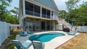 A two-story house with a swimming pool, outdoor furniture, and a covered patio area. - Happy Tides Hideaway/NEW!/Pool/Kids Adventure Room (Oak Island)