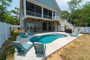 A two-story house with a swimming pool, outdoor furniture, and a covered patio area. - Happy Tides Hideaway/NEW!/Pool/Kids Adventure Room (Oak Island)