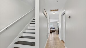 Un escalier menant à un espace de vie comprenant un canapé et une table basse.