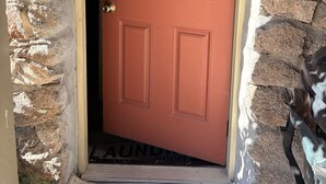 A door with a sign reading 'LAUNDRY' and a stone wall. - Fine Studio Nine @ Rustic Ridge in Granite Dells (Prescott)