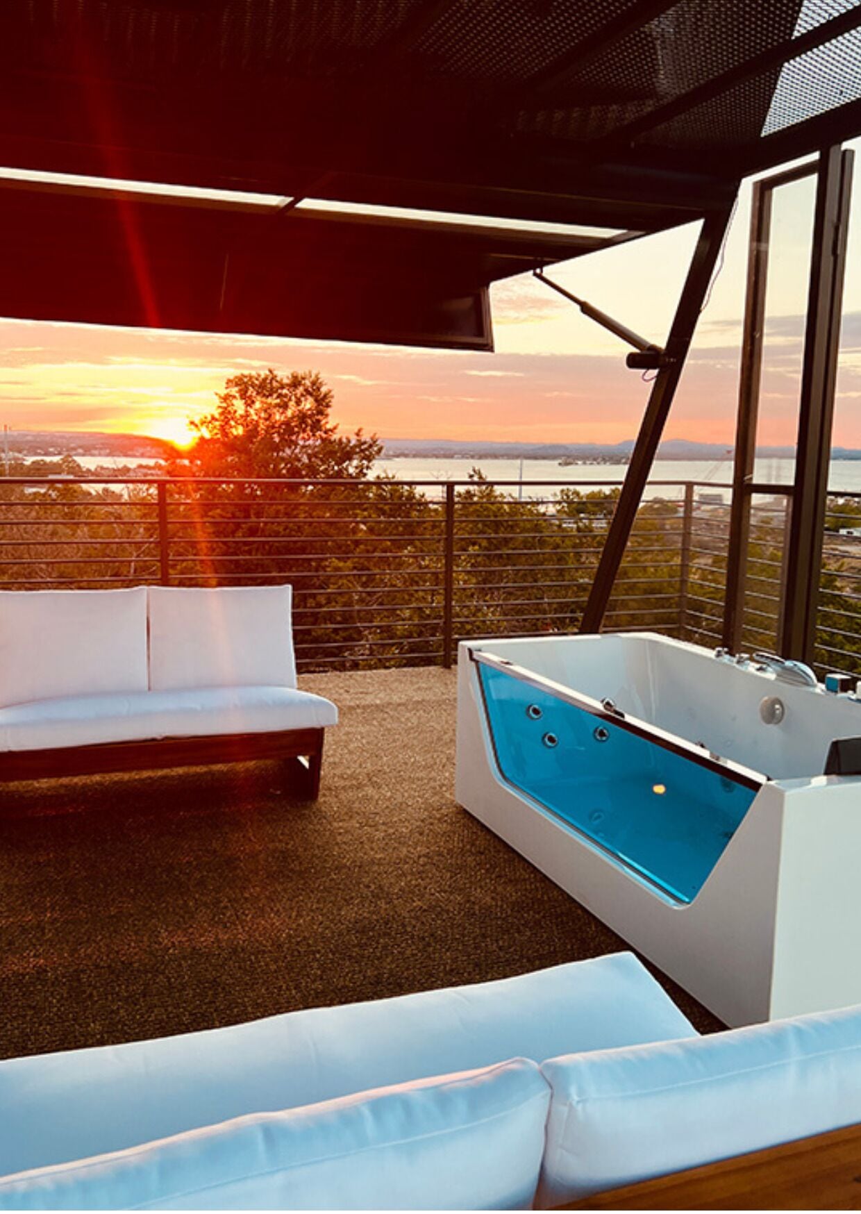 A balcony with a white sofa and a hot tub.