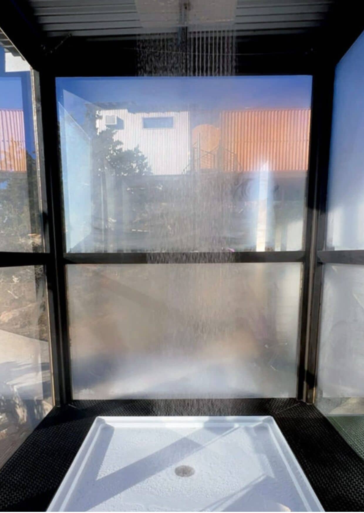 A window with a view of buildings and a clear sky.