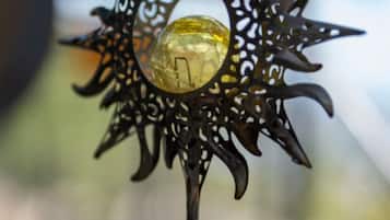 A decorative metal object with a glass sphere, a chain, and a circular base.