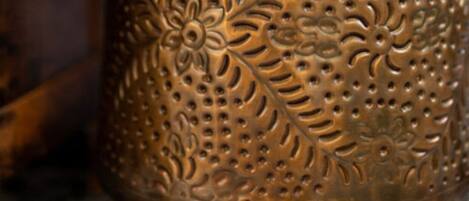 A brass decorative object with intricate floral patterns.