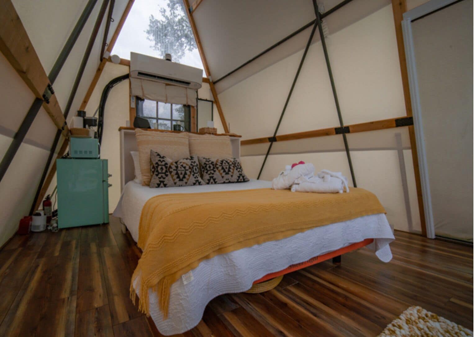 Ein Zeltraum mit einem Bett, einer Heizung und einem Fenster.