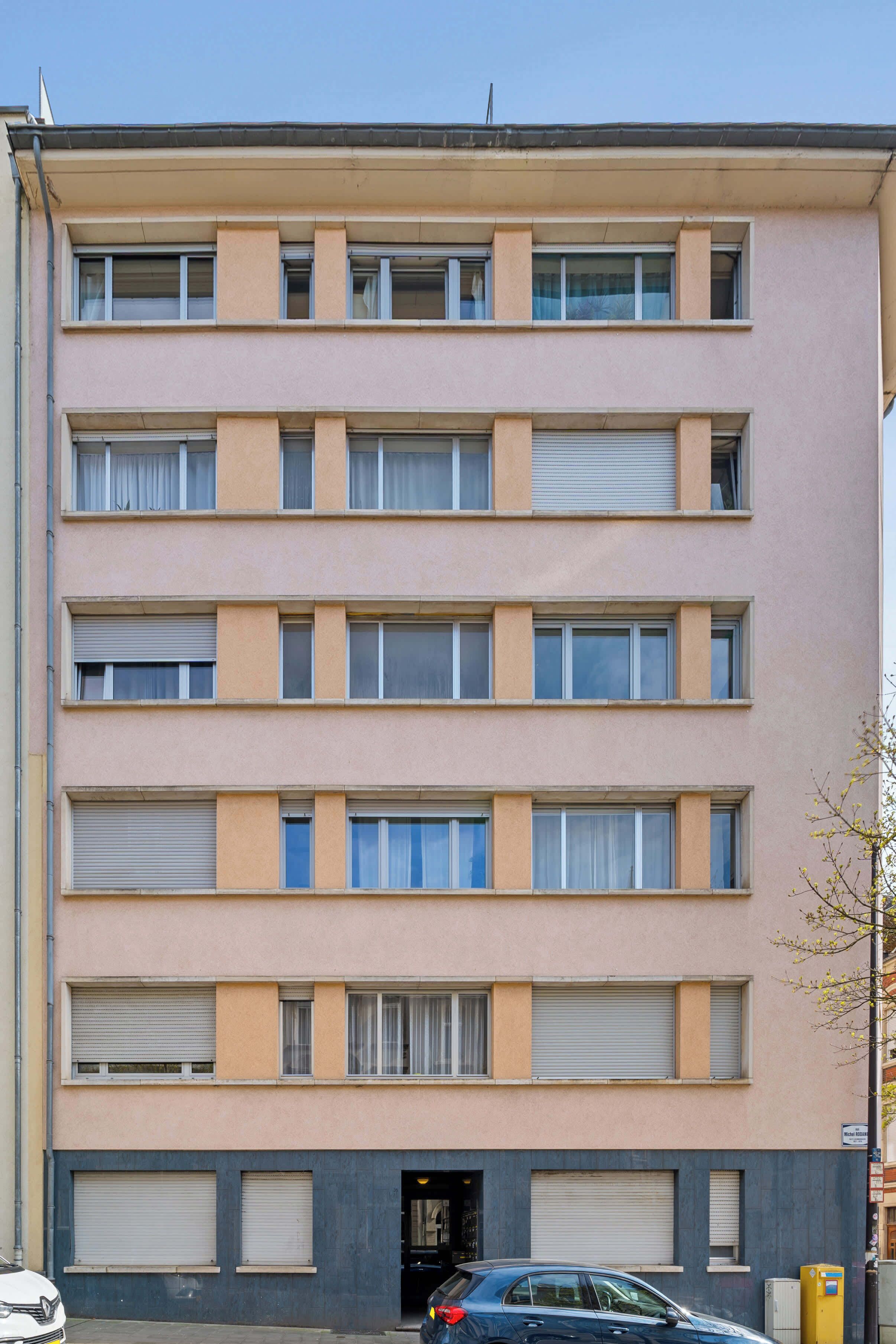 A multi-story building with a flat facade, large windows, and a garage entrance.