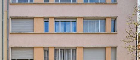 A multi-story building with a flat facade, large windows, and a garage entrance.