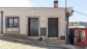 Ein Gebäude mit drei Türen, einem kleinen Fenster und einem Schornstein.